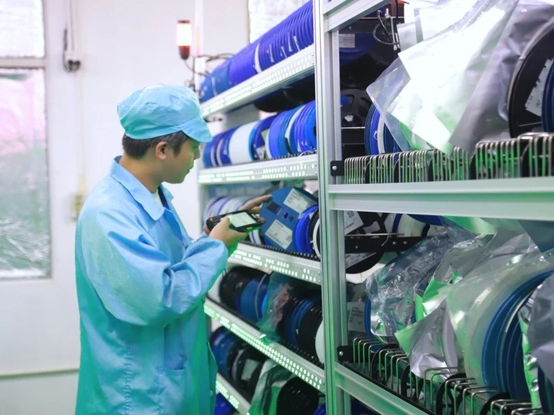 Component Lot and Material Traceability for PCBA Production Operator handling labeled component reels in an electronics material storage area