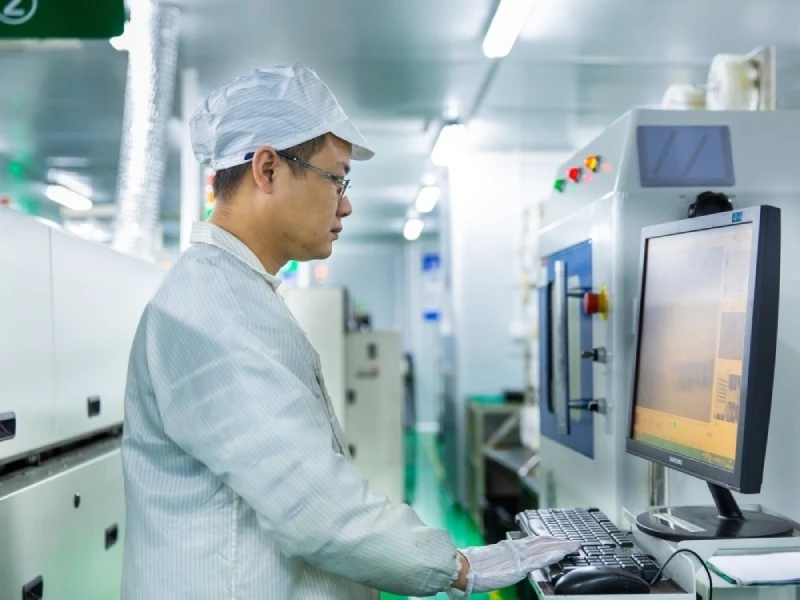 PCBA Manufacturing Process Evidence and Production Records PCBA production operator reviewing manufacturing process data at production equipment