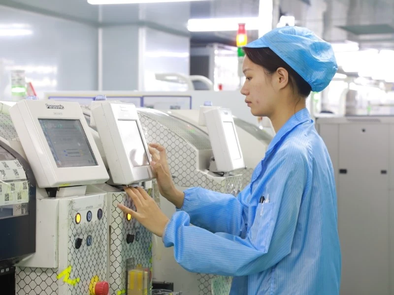 SMT Equipment Status Check During PCB Assembly SMT operator checking machine status and settings on a production equipment touchscreen