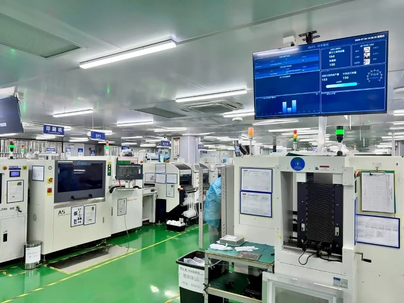 SMT Production Lines in an Electronics Manufacturing Facility Wide view of a clean electronics manufacturing facility with SMT assembly and inspection equipment