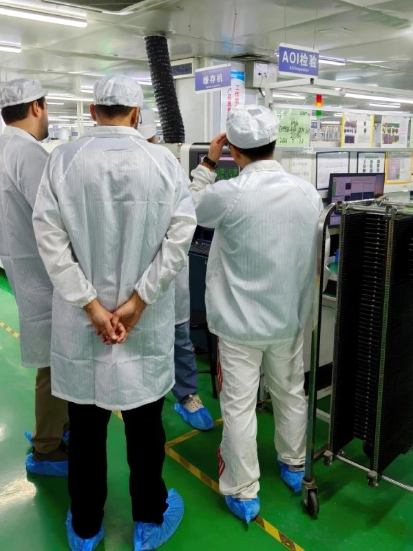STHL engineer explaining automated optical inspection equipment to two visitors from Saudi Arabia