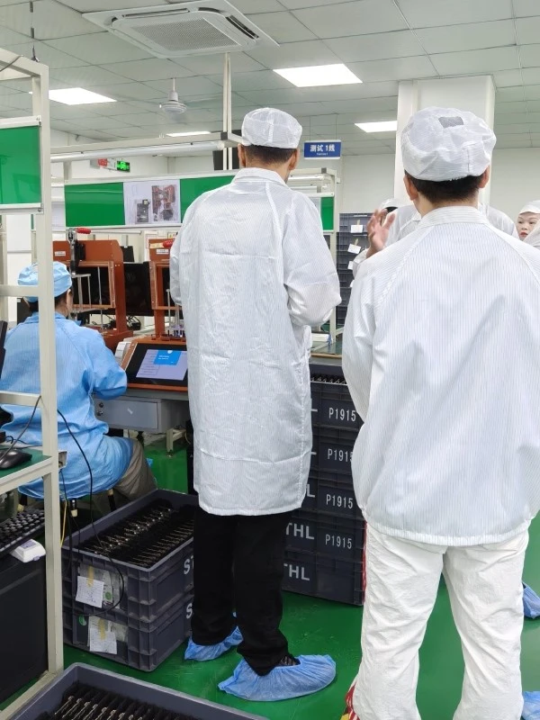 Two visitors from Saudi Arabia reviewing the SMT production line and pick-and-place machines at STHL