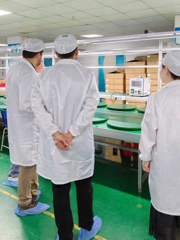 Two visitors from Saudi Arabia reviewing leak-testing equipment used for enclosure sealing checks at STHL