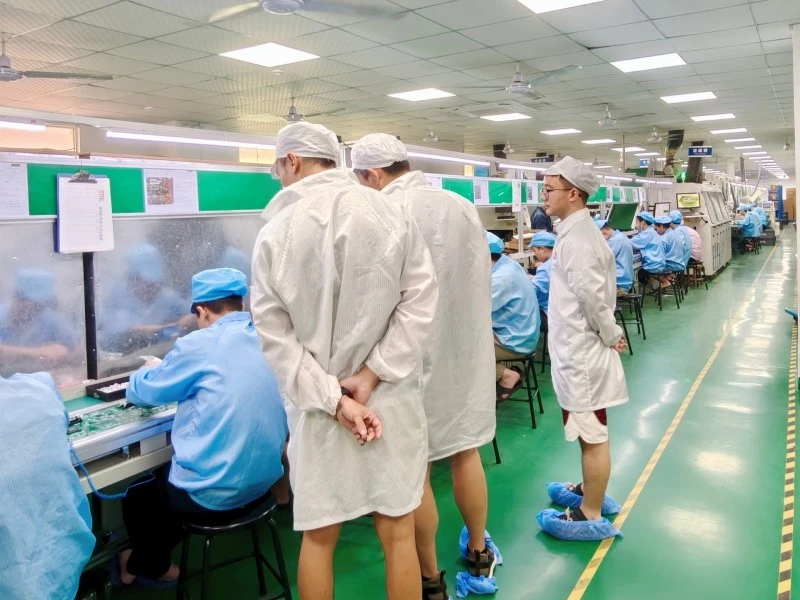 Visitors observing THT/DIP assembly operations during the factory walkthrough at STHL