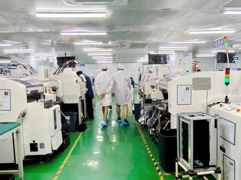 Visitors reviewing the SMT production area and PCB assembly equipment at STHL