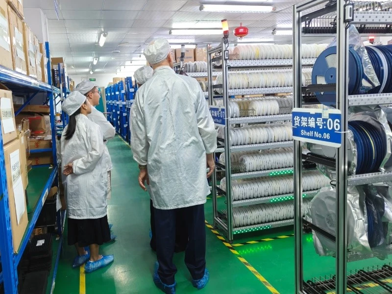 STHL MES-Integrated Electronic Component Storage Visitors viewing electronic components stored on MES-integrated smart racks at STHL
