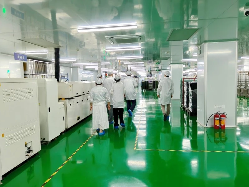 STHL SMT Production Line - Reflow Soldering and PCB Buffer Conveyor Italian visitors touring the SMT reflow oven and PCB buffer conveyor area at STHL